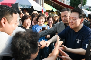 윤석열 대통령이 여름휴가 첫날인 지난 5일 오후 경남 통영중앙시장을 찾아 시민들과 인사를 나누고 있다. 뉴스1