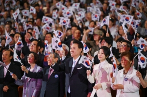 윤석열 대통령과 김건희 여사가 15일 서울 종로구 세종문화회관에서 열린 제79주년 광복절 경축식에서 태극기를 흔들고 있다. 윤 대통령은 경축사에서 “완전한 광복은 바로 통일”이라고 말했다. 사진=대통령실 제공