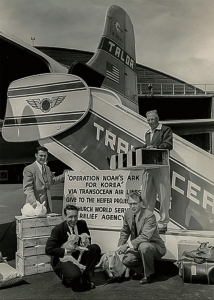 1954년 4월 미국 오클랜드에서 헤퍼인터내셔널 관계자들이 한국으로 보낼 꿀벌 통(오른쪽 위 남성이 든 상자)과 염소, 토끼를 안고 수송기 앞에서 기념촬영을 하고 있다. ‘한국을 위한 노아의 방주 작전’이라는 안내판이 보인다. 사진=헤퍼코리아